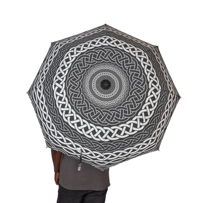 Person holding a black and white patterned umbrella on a white background