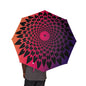 Umbrella with a geometric pattern in red, black, and purple held by a person.