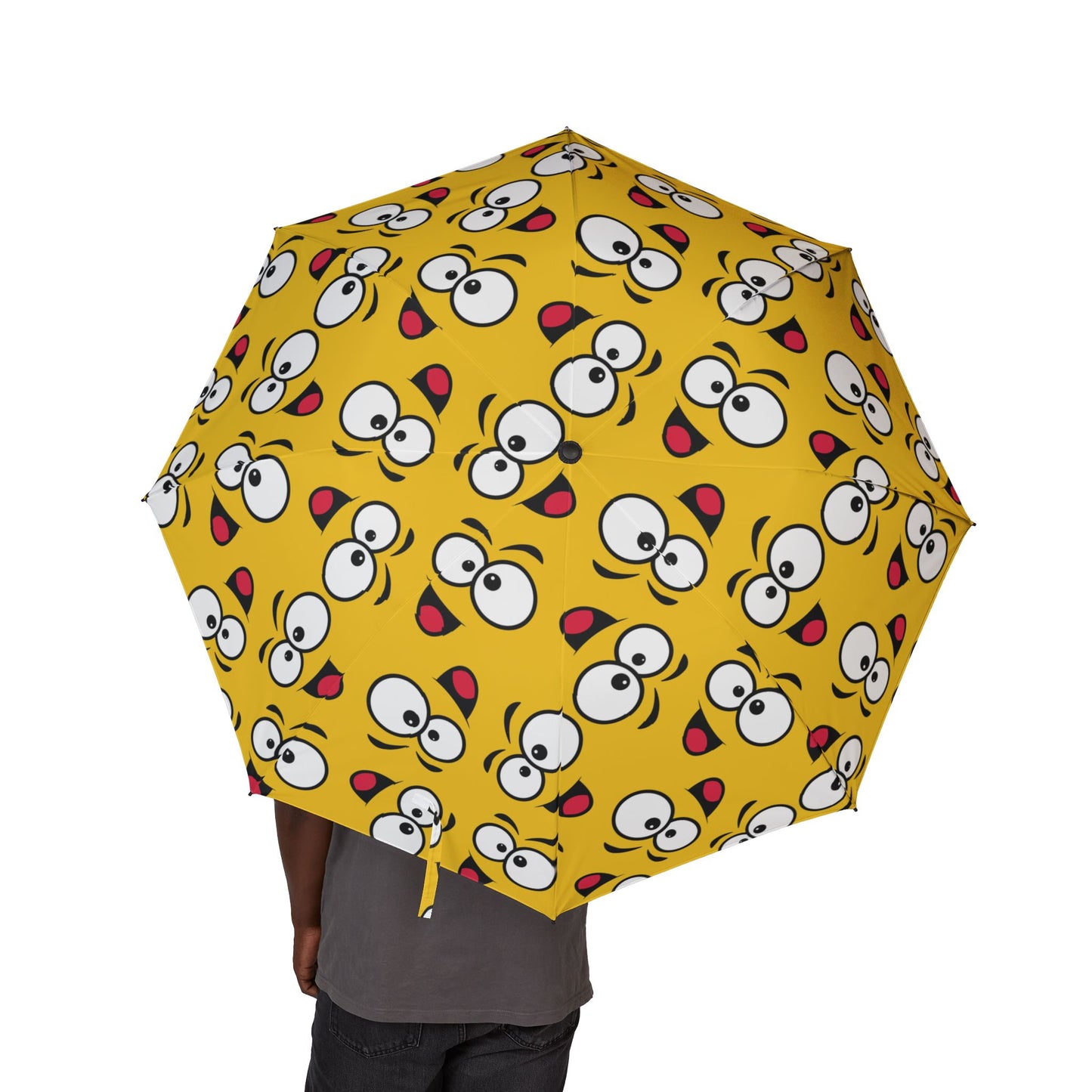 Yellow umbrella with cartoon face pattern on a white background