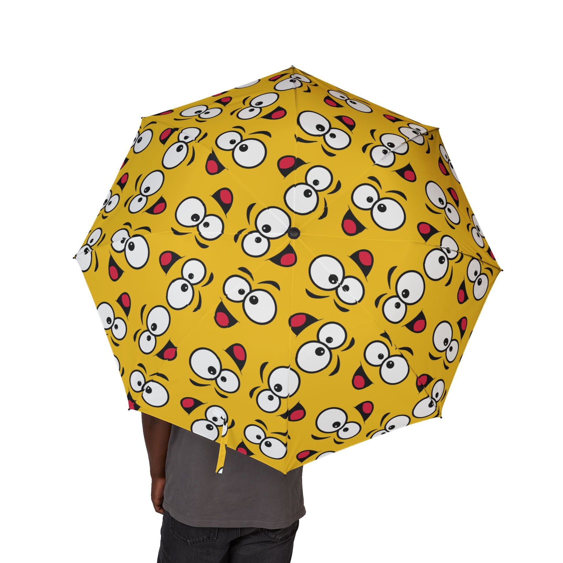 Yellow umbrella with cartoon face pattern on a white background