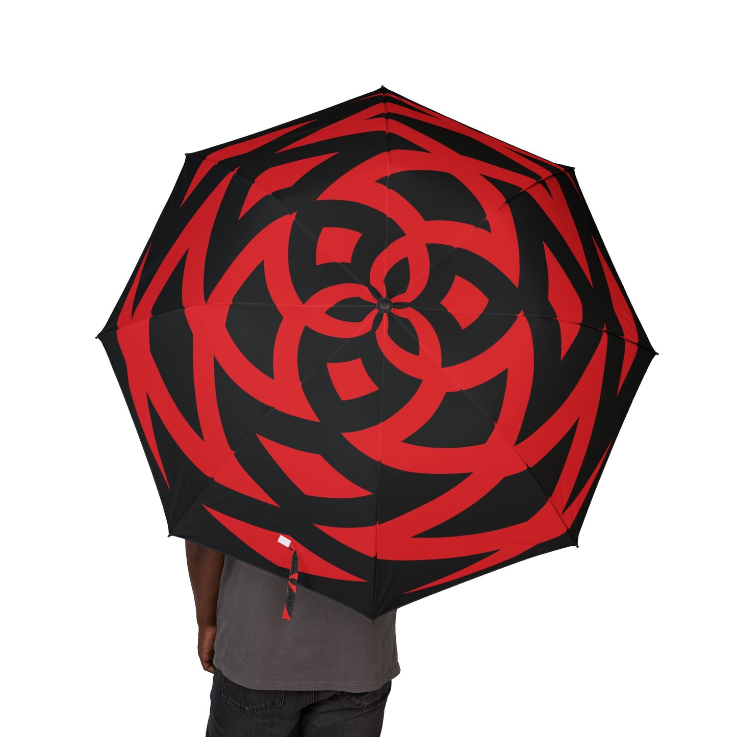 Red and black patterned umbrella held by a person on a white background