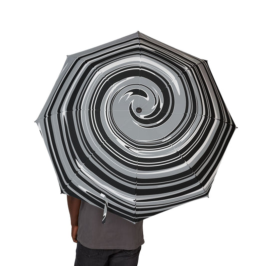 Umbrella with a black and white and silver spiral pattern held by a person on a white background