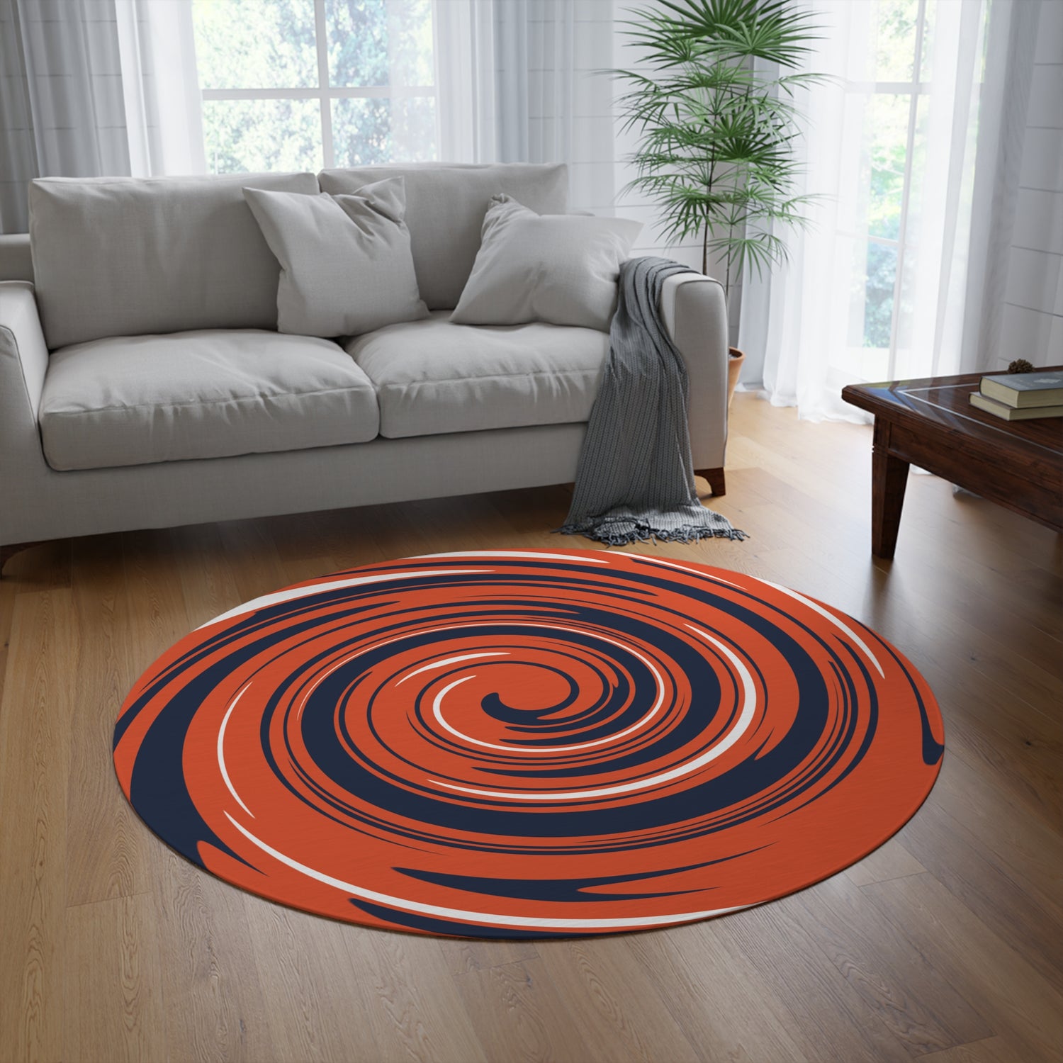 Round orange and blue rug on a wooden floor in a living room with a gray sofa and coffee table.