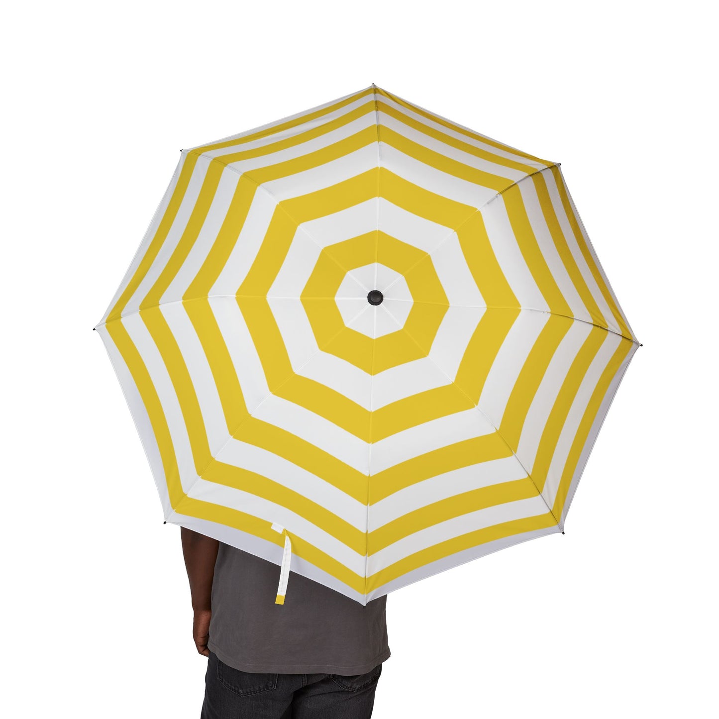 Yellow and white striped umbrella held by a person on a white background