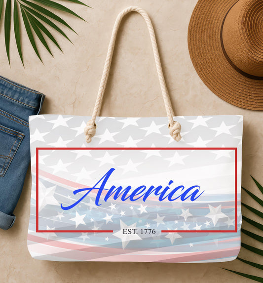 Bag with 'America' text and American flag design, placed on a beige surface with a hat and jeans.