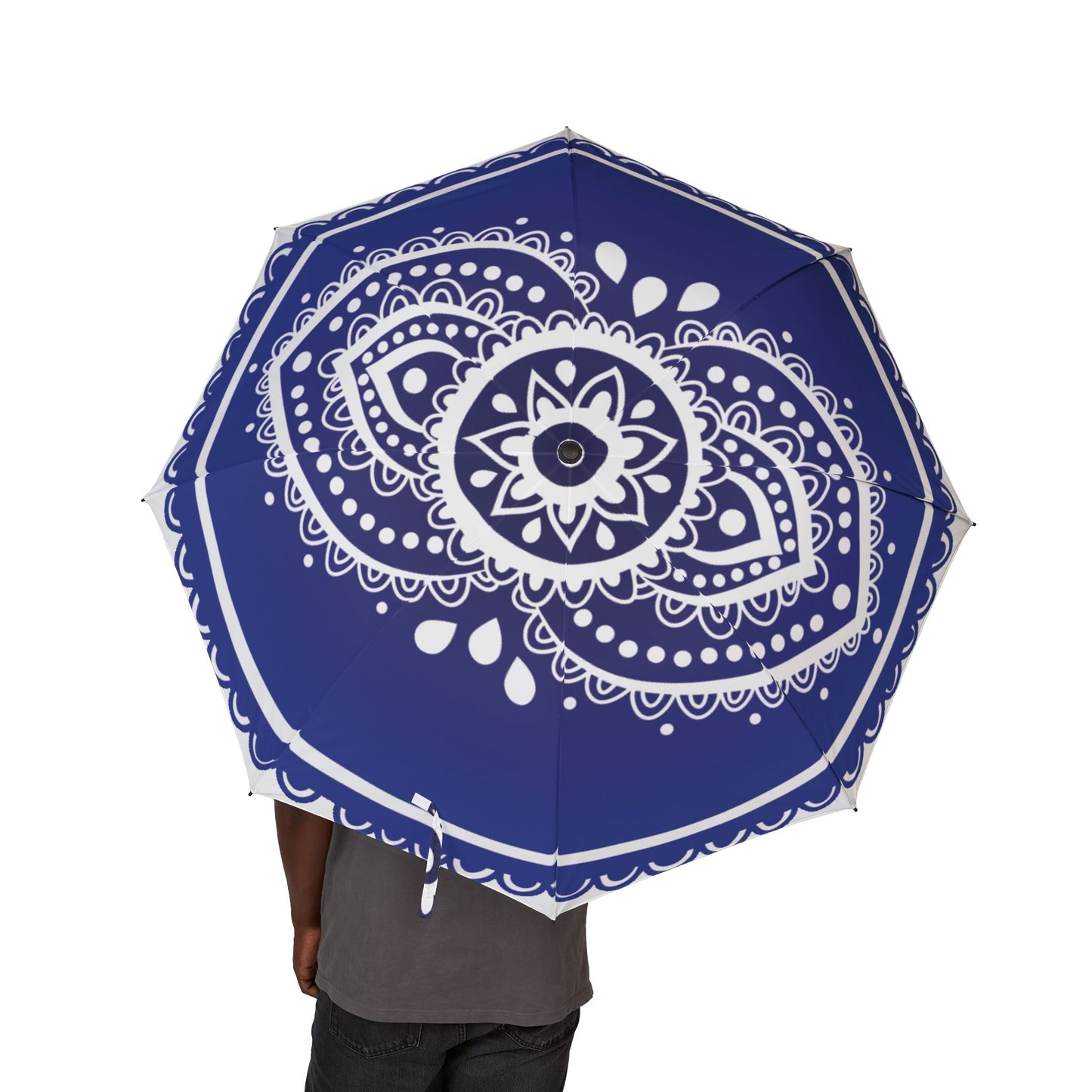 Blue umbrella with white mandala design held by a person on a white background