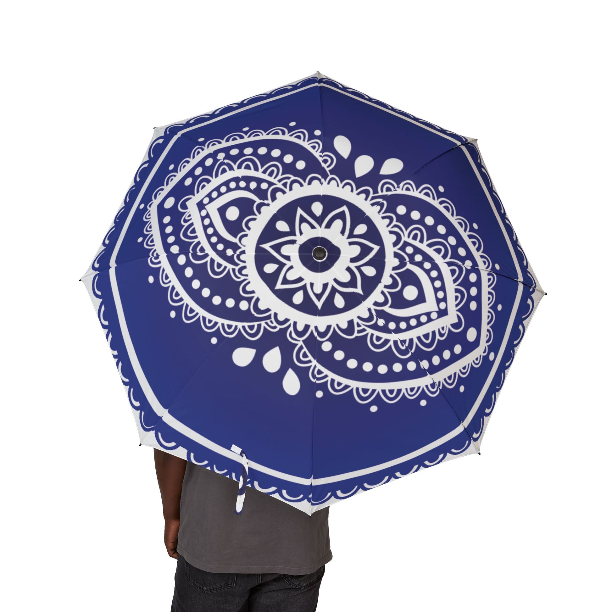 Blue umbrella with white mandala design held by a person on a white background