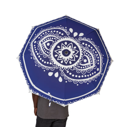 Blue umbrella with white mandala design held by a person on a white background