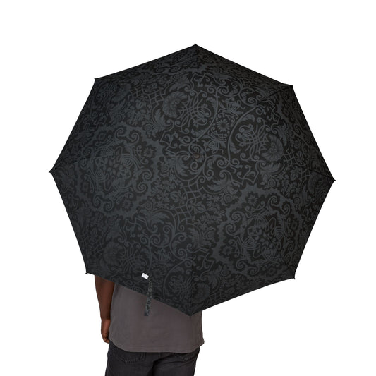 Black patterned umbrella held by a person on a white background