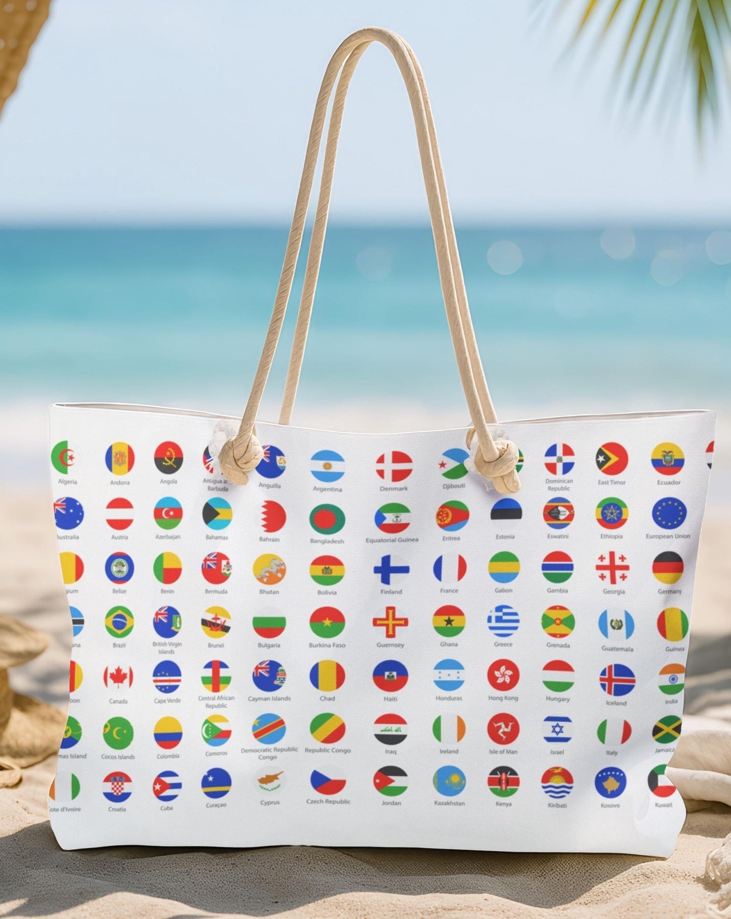 Beach bag with international flags on a sandy beach with a hat and sunglasses.