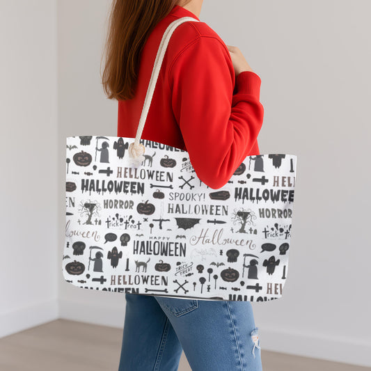 Person holding a tote bag with Halloween-themed design against a plain background